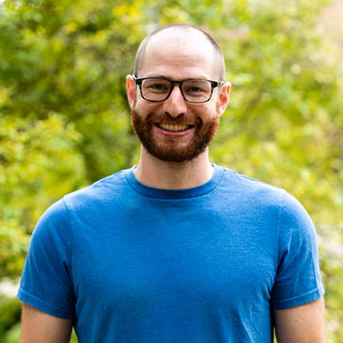 person with glasses in front of tree